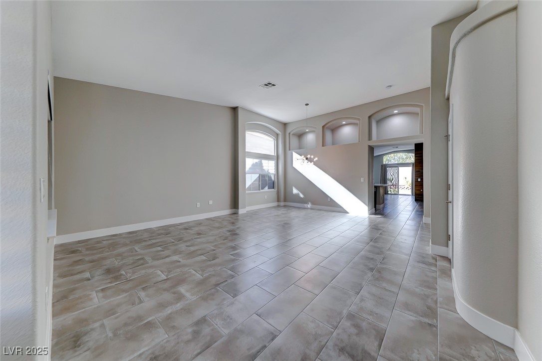 2401 Flower Spring Street Las Vegas, NV 89134 - Photo 8 of 42 Unfurnished living room with a chandelier and light tile patterned floors