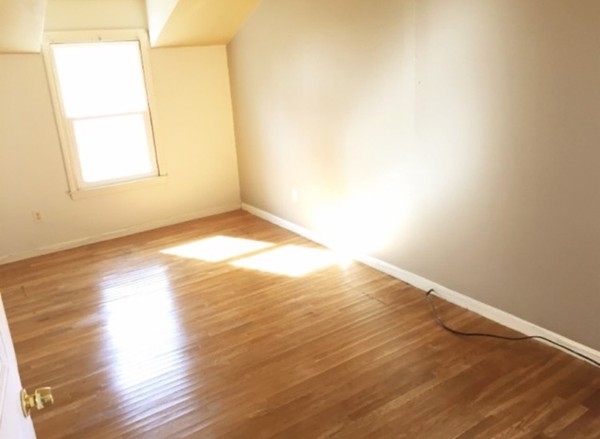284 Plumtree Road Springfield, MA 01118 - Photo 5 of 8 an empty room with wooden floor and windows