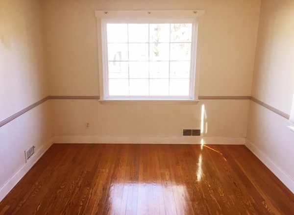284 Plumtree Road Springfield, MA 01118 - Photo 6 of 8 an empty room with wooden floor and windows