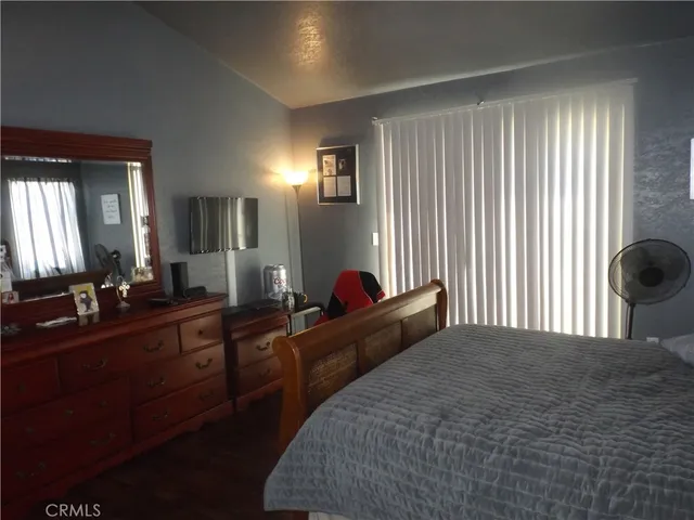 a bedroom with a bed and two windows