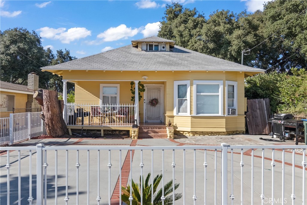 a view of a house with wooden fence next to a house