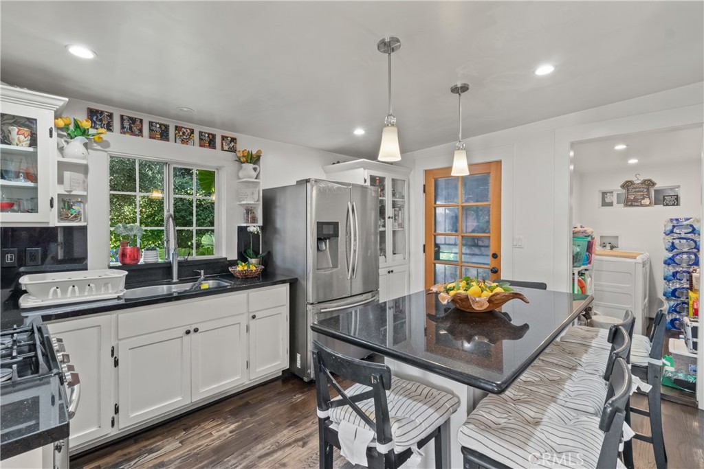 63 Yale Street Pasadena, CA 91103 - Photo 28 of 50 a kitchen with stainless steel appliances granite countertop a refrigerator a sink dishwasher a dining table and chairs with wooden floor