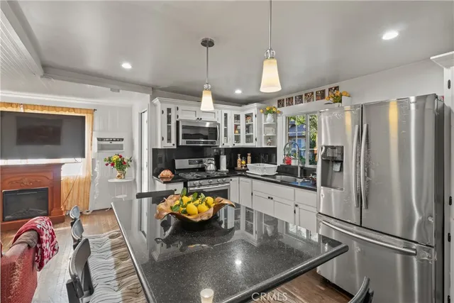 a living room with furniture a fireplace and a open kitchen view