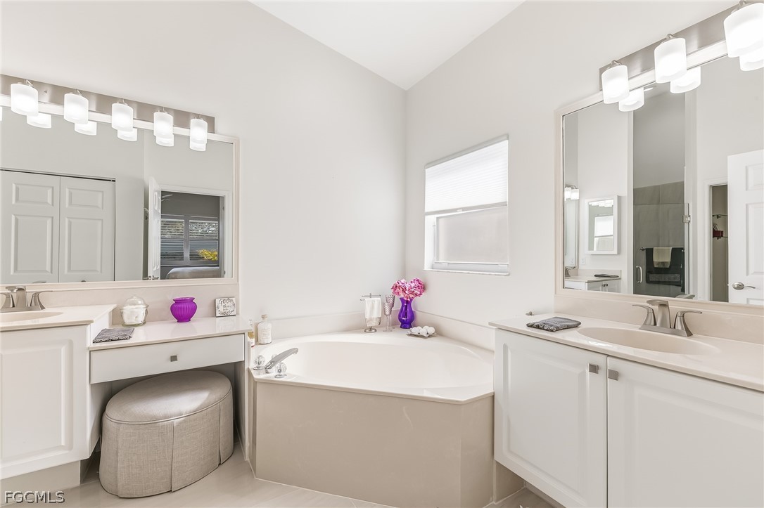 9004 Springview Loop Estero, FL 33928 - Photo 15 of 41 a bathroom with a sink vanity tub and a mirror