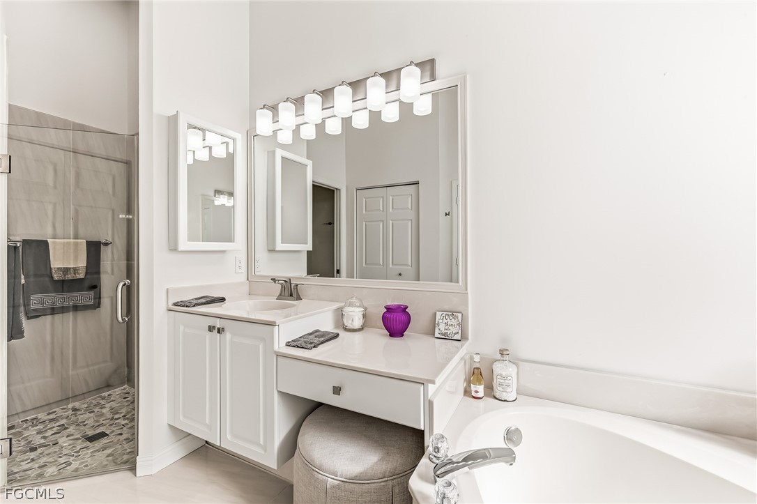 9004 Springview Loop Estero, FL 33928 - Photo 16 of 41 a bathroom with a sink vanity tub and shower