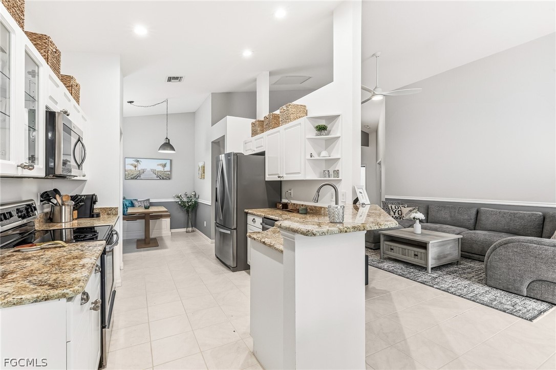 9004 Springview Loop Estero, FL 33928 - Photo 20 of 41 a kitchen with stainless steel appliances kitchen island granite countertop a refrigerator and a stove top oven