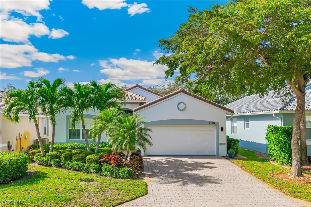 9004 Springview Loop Estero, FL 33928 - Photo 2 of 41 a front view of a house with a yard and potted plants