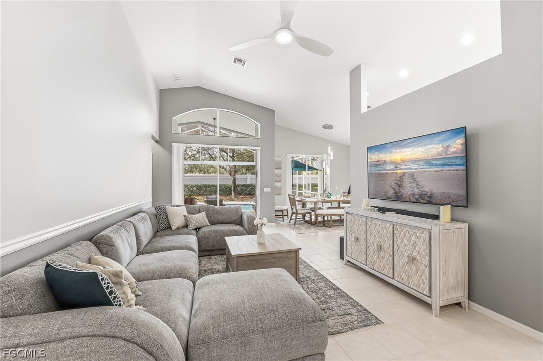 9004 Springview Loop Estero, FL 33928 - Photo 3 of 41 a living room with furniture a flat screen tv and a large window