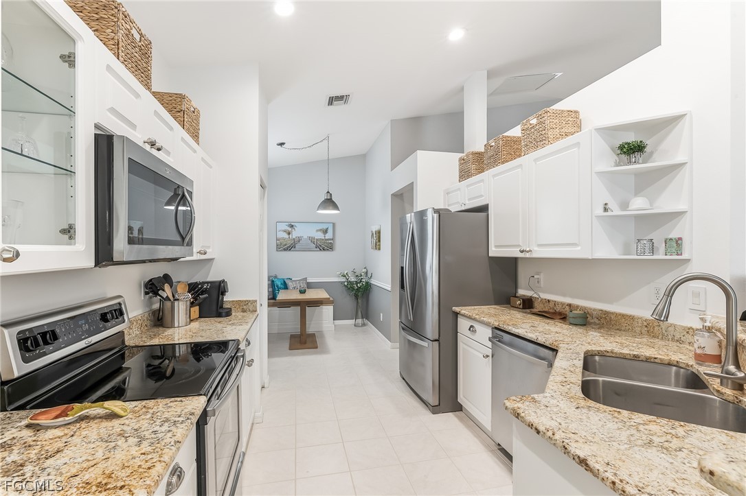 9004 Springview Loop Estero, FL 33928 - Photo 5 of 41 a kitchen with stainless steel appliances granite countertop a sink stove and refrigerator