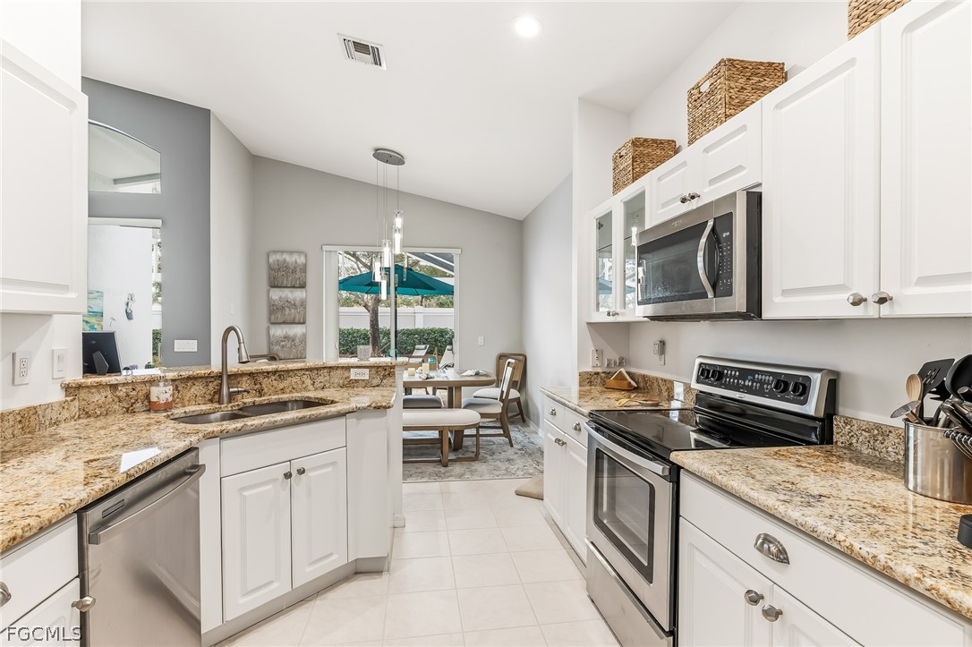 9004 Springview Loop Estero, FL 33928 - Photo 6 of 41 a kitchen with stainless steel appliances granite countertop a sink stove and microwave