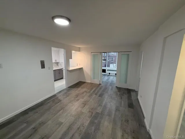 a view of a kitchen with wooden floor and electronic appliances
