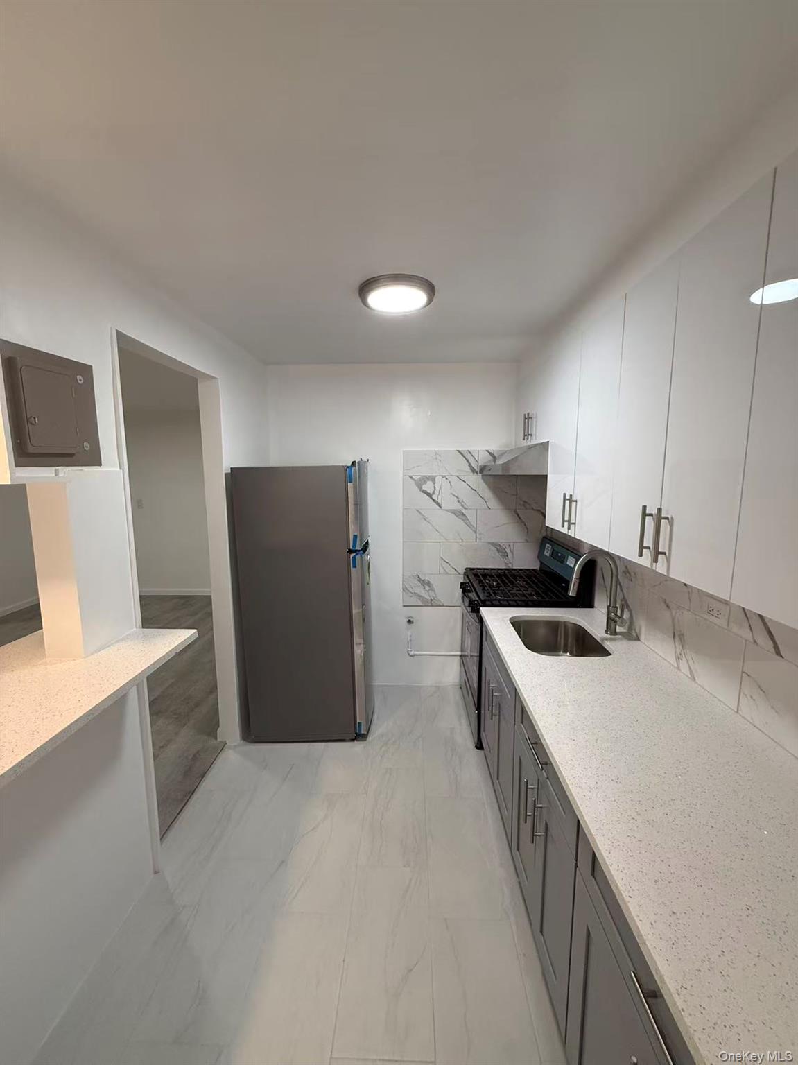 42-26 81st Street, Unit 2J Queens, NY 11373 - Photo 5 of 14 a kitchen with stainless steel appliances a white refrigerator a sink a stove and a refrigerator