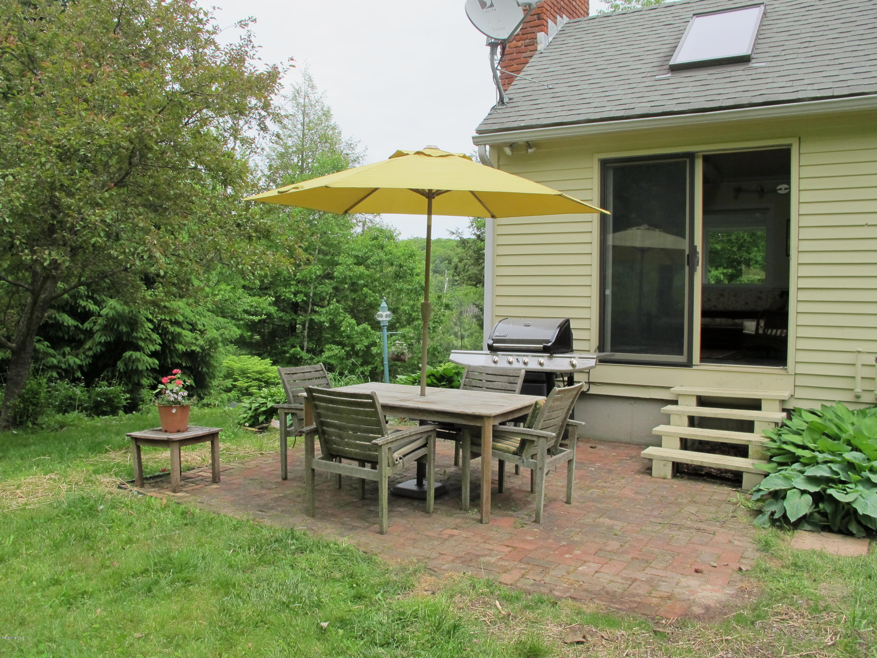 4 Stonebridge Way Tyringham, MA 01264 - Photo 30 of 40 a backyard of a house with table and chairs