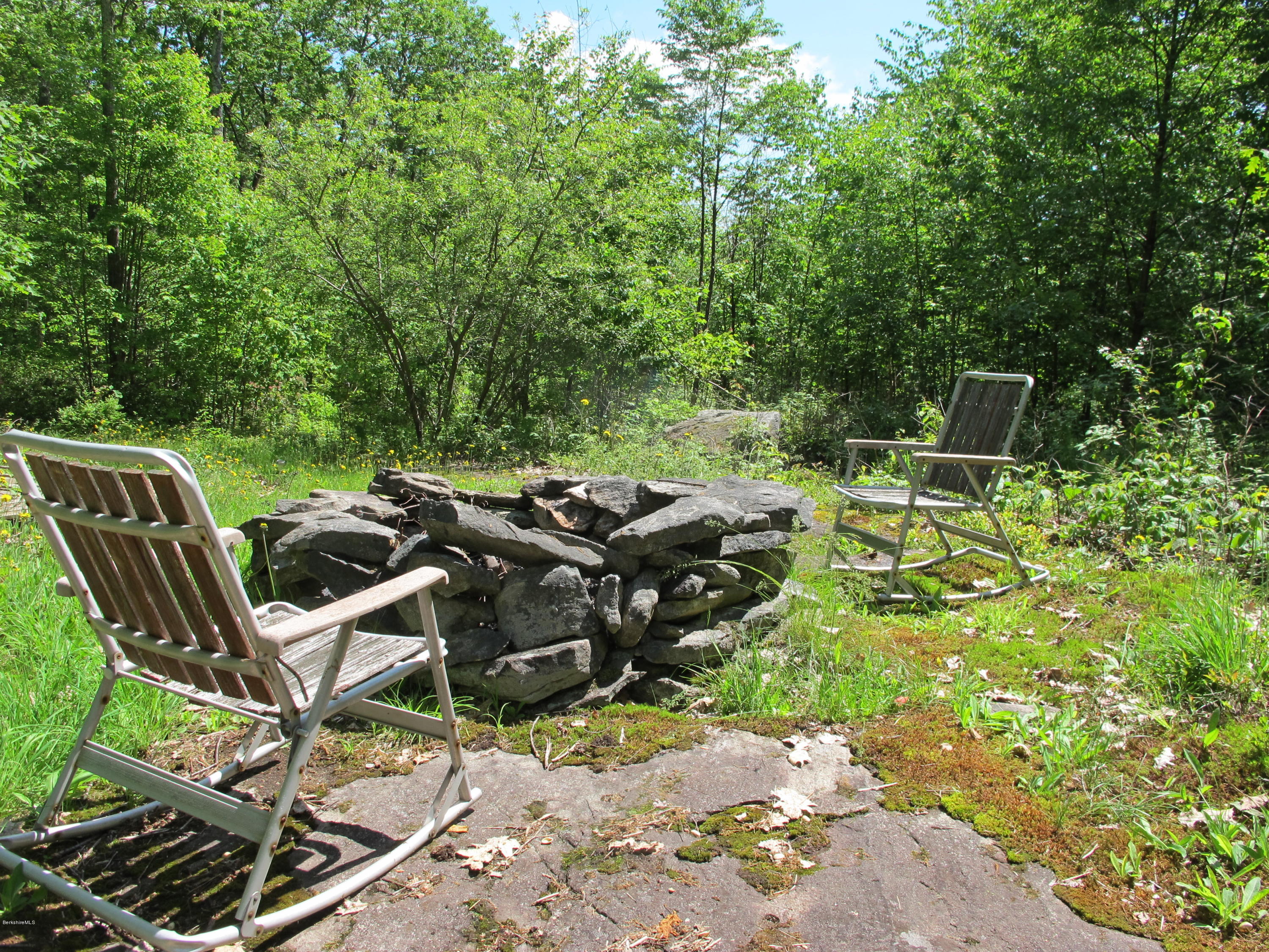 4 Stonebridge Way Tyringham, MA 01264 - Photo 40 of 40 a backyard of a house with table and chairs