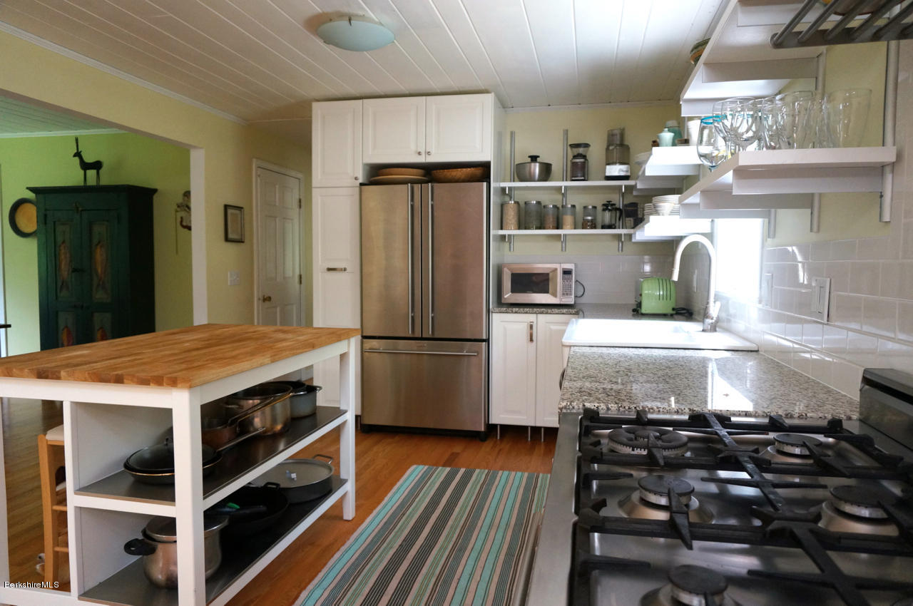 4 Stonebridge Way Tyringham, MA 01264 - Photo 5 of 40 a kitchen that has a lot of cabinets a stove and a refrigerator