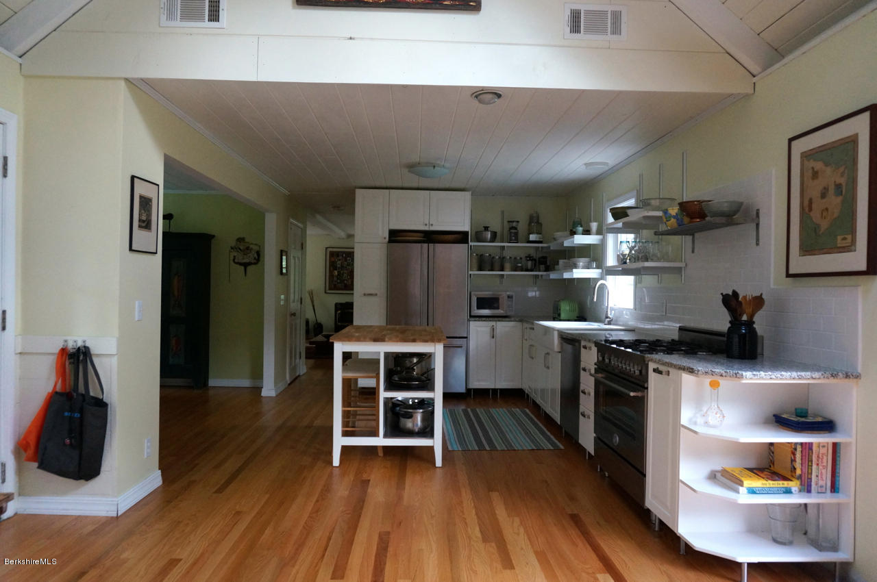 4 Stonebridge Way Tyringham, MA 01264 - Photo 6 of 40 a kitchen with stainless steel appliances a stove a refrigerator and wooden cabinets