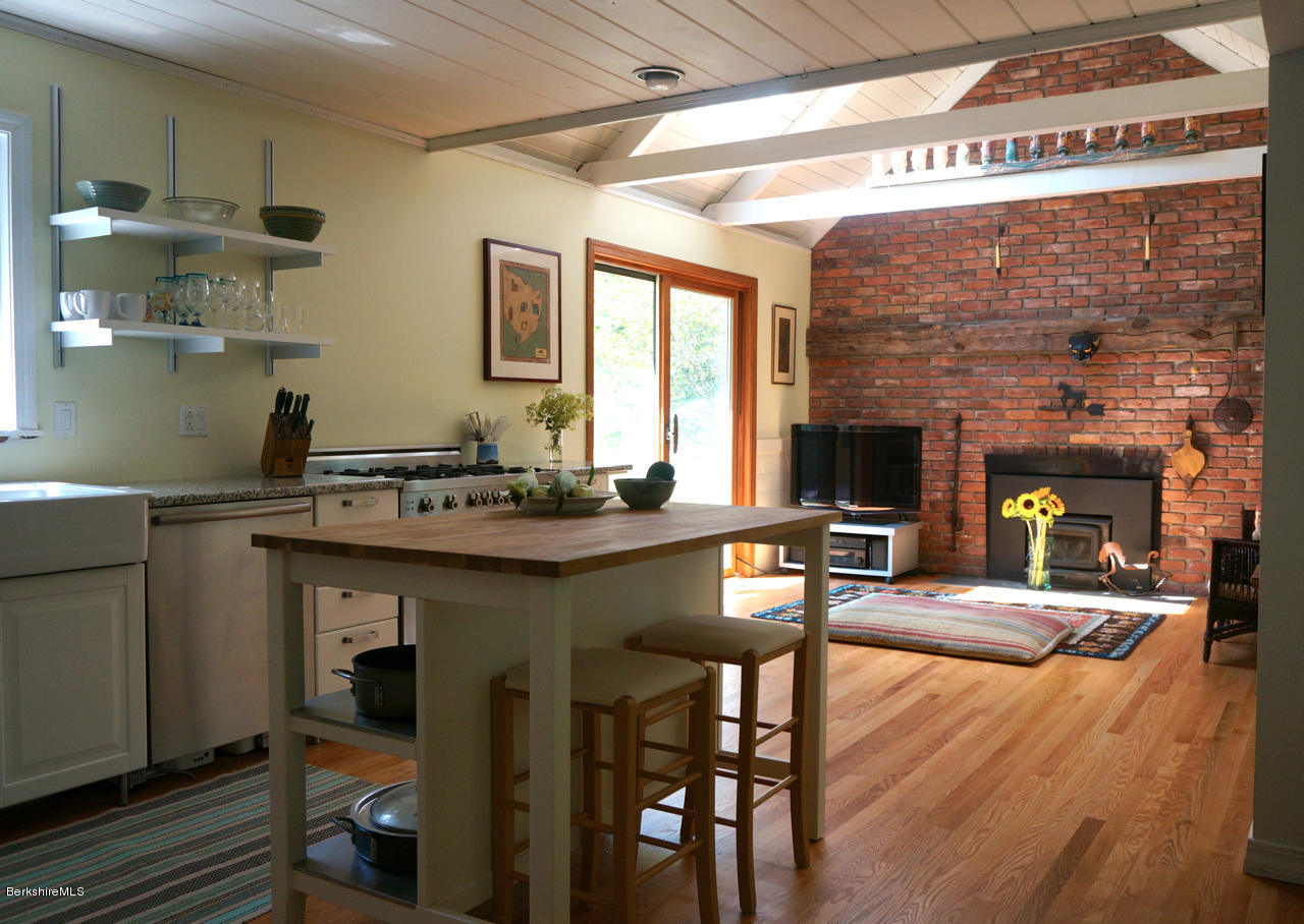 4 Stonebridge Way Tyringham, MA 01264 - Photo 7 of 40 a kitchen with a table chairs and a refrigerator
