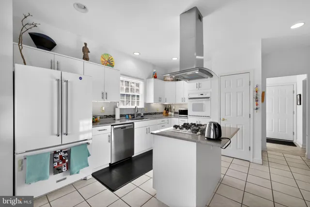 a view of living room with stainless steel appliances furniture and a book shelf