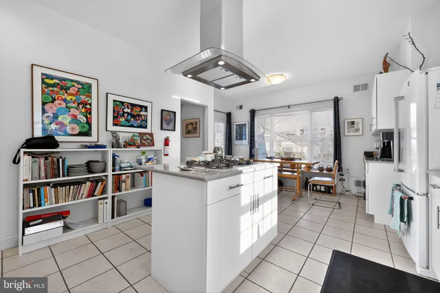 a open kitchen with stainless steel appliances granite countertop a stove a sink dishwasher and white cabinets with wooden floor