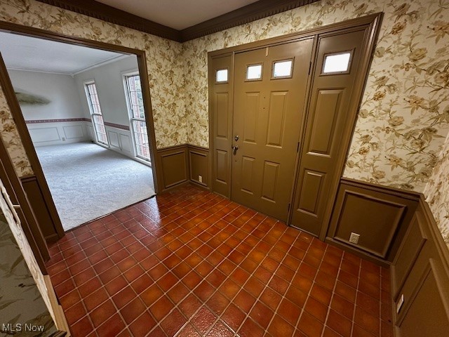 3508 Miller Road Sandusky, OH 44870 - Photo 5 of 30 Entrance foyer with a decorative wall, a wainscoted wall, crown molding, and dark tile patterned floors