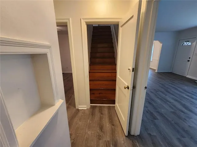 a view of a hallway with wooden floor and stairs