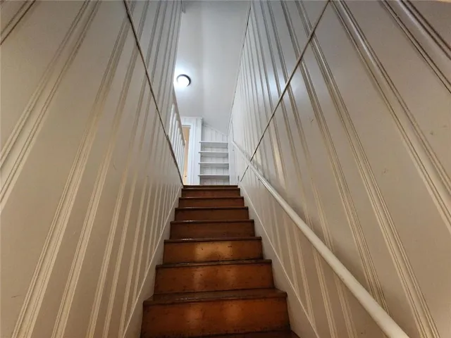 a view of staircase with wooden floor and white walls