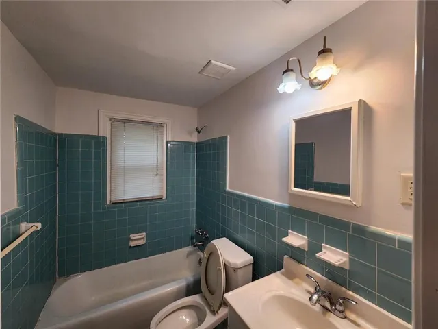 a bathroom with a toilet a sink and bathtub