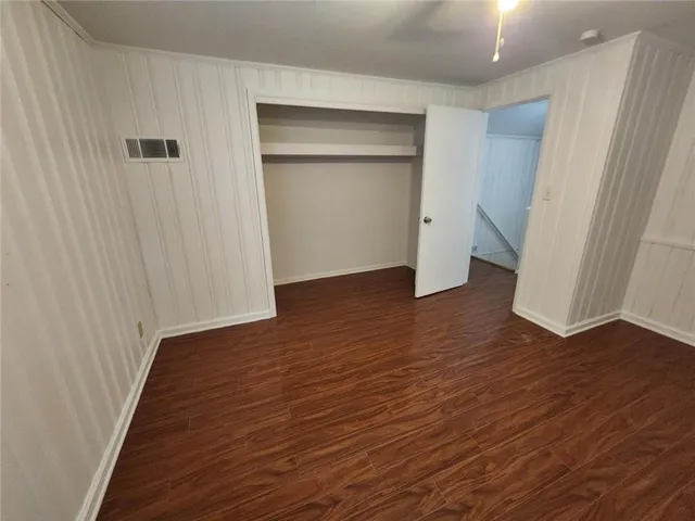 an empty room with wooden floor and closet