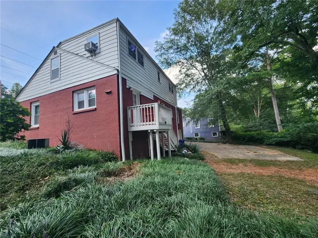 a front view of a house with yard and trees