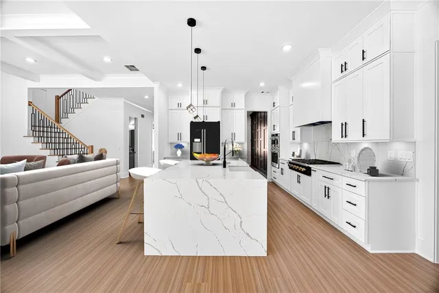 a large white kitchen with stainless steel appliances