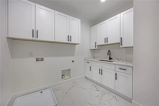 a kitchen with white cabinets and sink