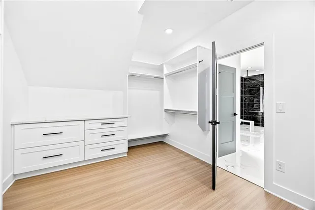 a view of walk in closet with empty racks