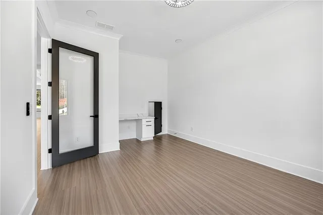 an empty room with wooden floor and a bathroom