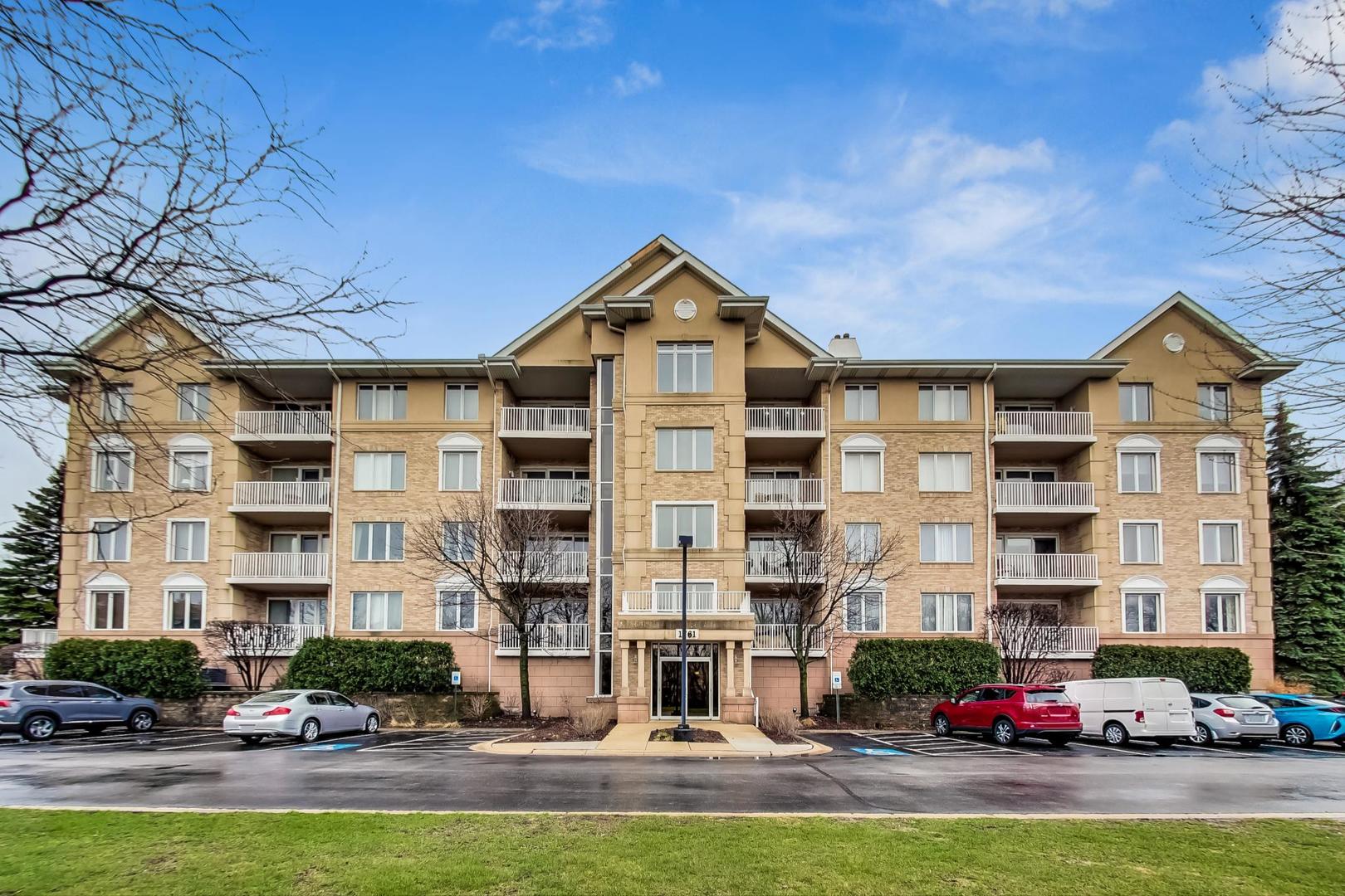 1761 Pavilion Way, Unit 306 Park Ridge, IL 60068 - Photo 1 of 19 a front view of a building with lot of cars parked in front of it