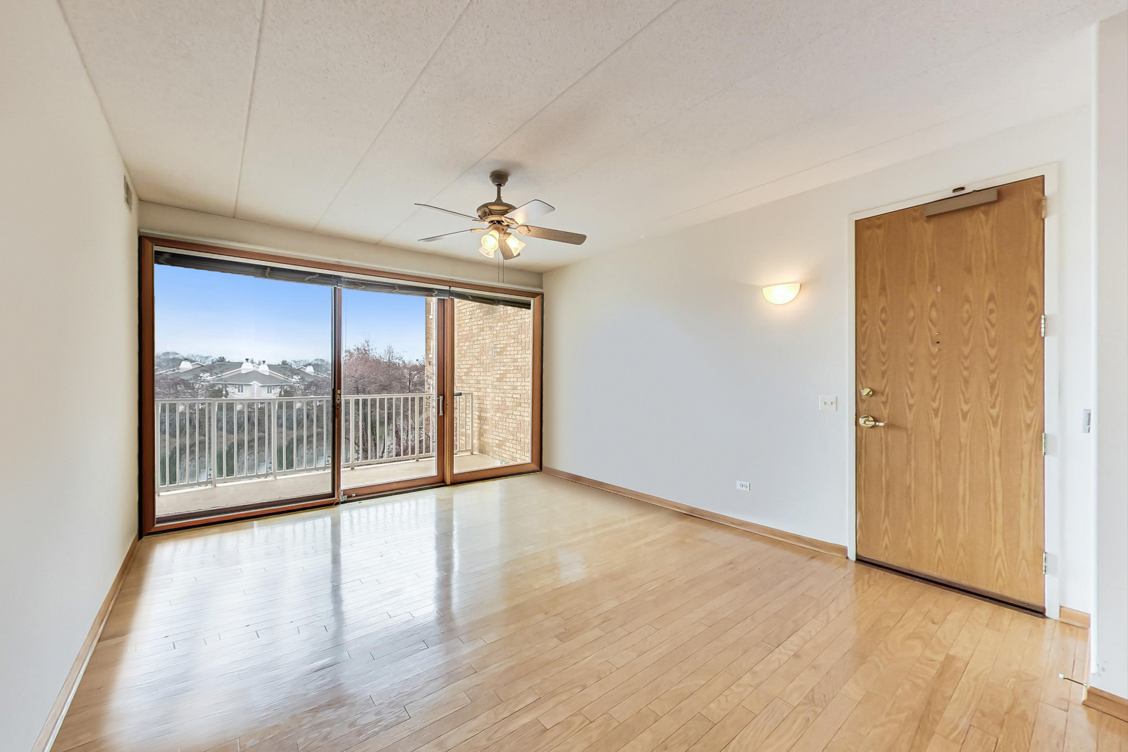 1761 Pavilion Way, Unit 306 Park Ridge, IL 60068 - Photo 3 of 19 a view of an empty room with wooden floor and a window