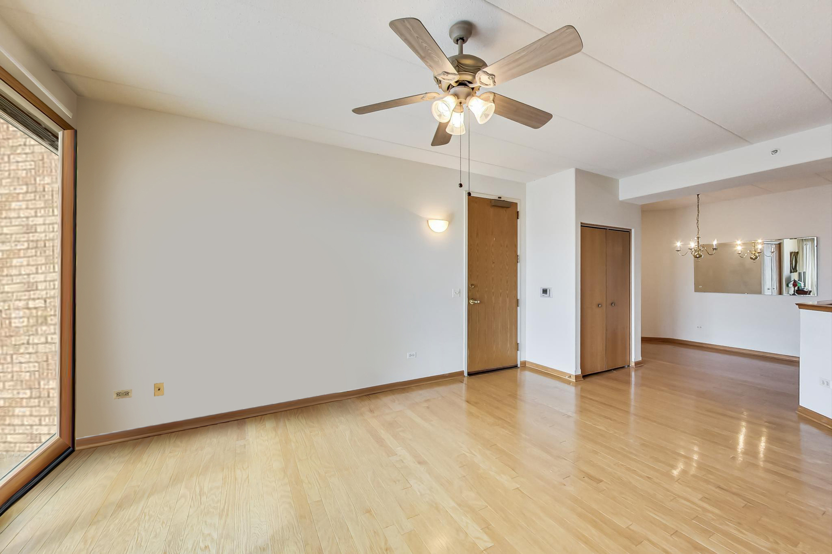 1761 Pavilion Way, Unit 306 Park Ridge, IL 60068 - Photo 4 of 19 an empty room with wooden floor and windows