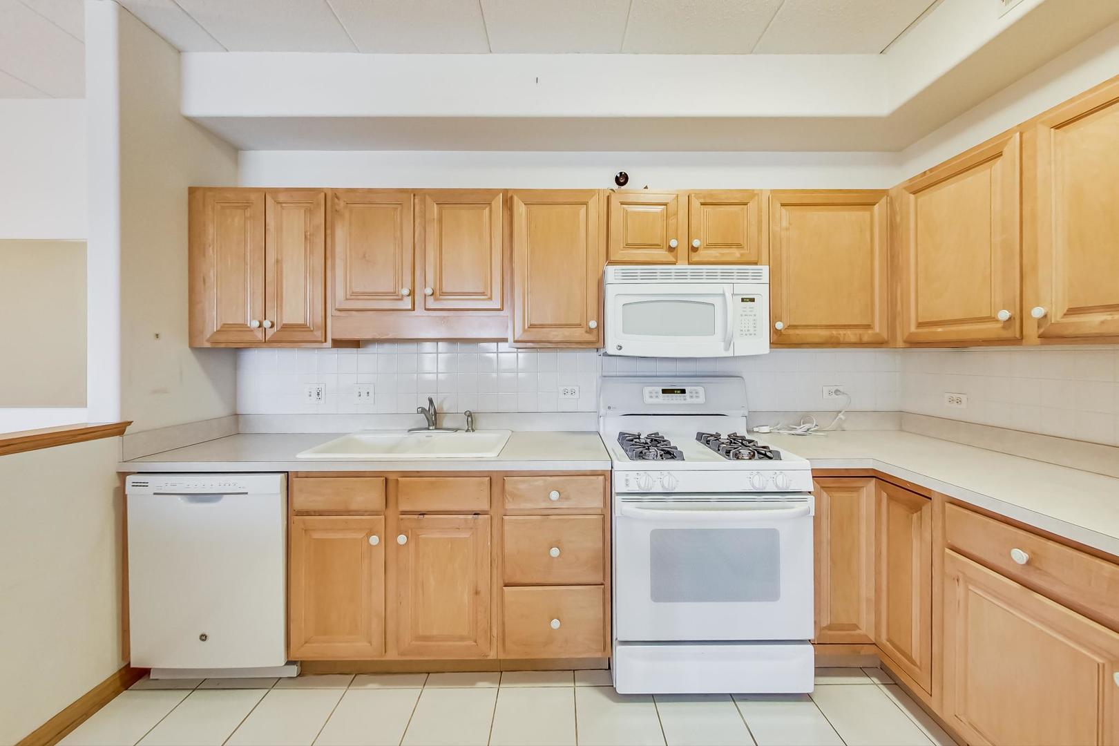 1761 Pavilion Way, Unit 306 Park Ridge, IL 60068 - Photo 6 of 19 a kitchen with cabinets appliances a sink and a window