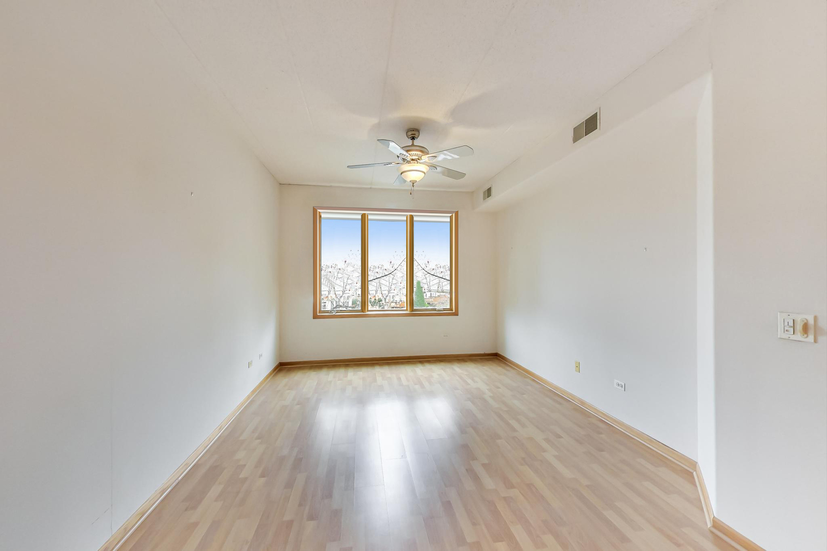 1761 Pavilion Way, Unit 306 Park Ridge, IL 60068 - Photo 8 of 19 an empty room with wooden floor chandelier fan and windows