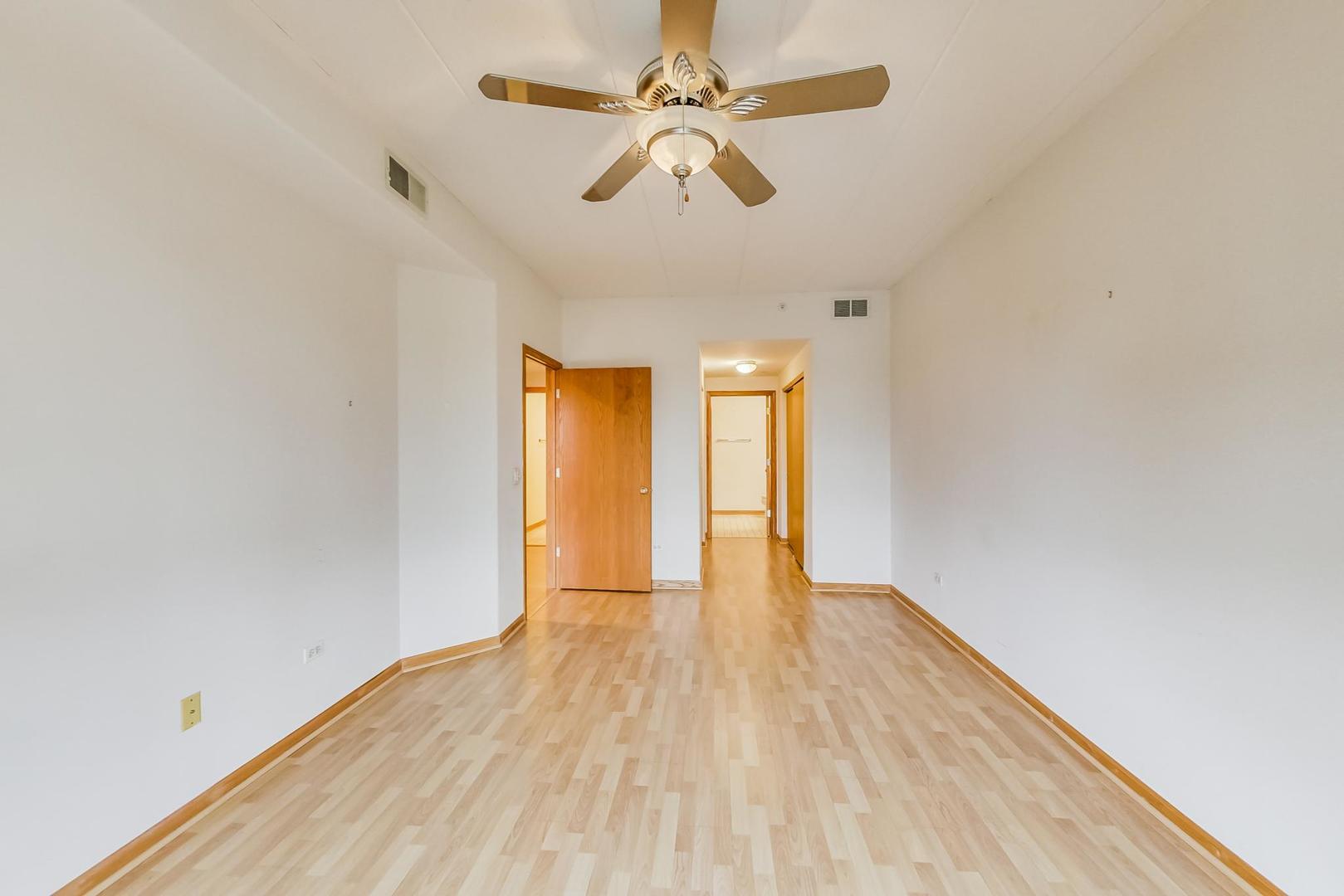 1761 Pavilion Way, Unit 306 Park Ridge, IL 60068 - Photo 9 of 19 a view of an empty room with window and wooden floor