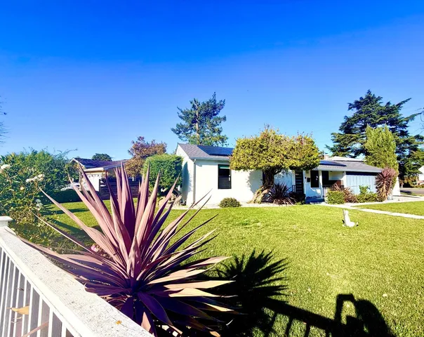 a view of a house with backyard and sitting area