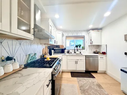 a kitchen with stove a sink and cabinets