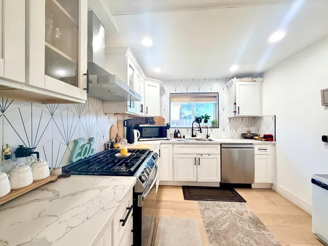 a kitchen with stove a sink and cabinets