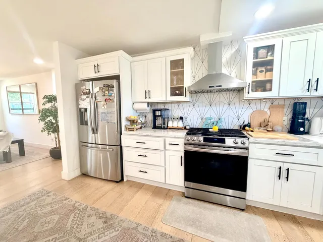 a kitchen with stainless steel appliances white cabinets and a refrigerator