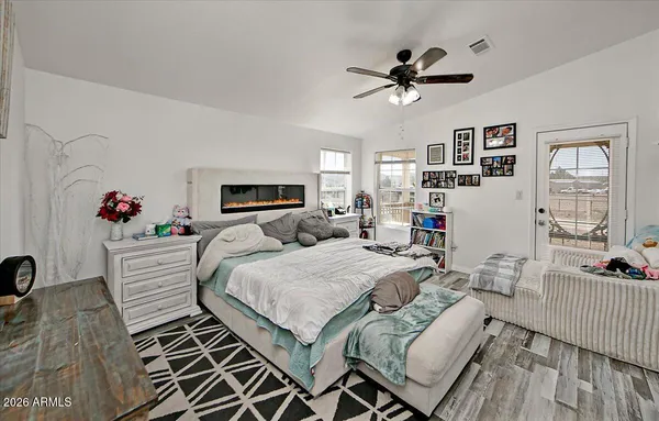 a bed room with a bed couches and a flat tv screen