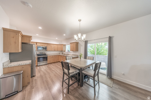 4765 Breezy Patch Road Eagle Mountain, UT 84005 - Photo 8 of 25 Kitchen with wood-finish flooring, light wood cabinetry, granite countertops, and stainless steel appliances