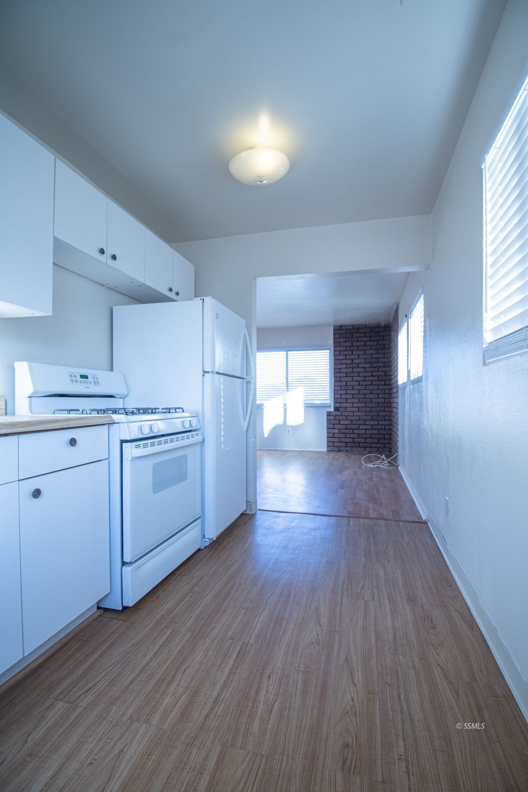 1621 Sims Street Ridgecrest, CA 93555 - Photo 9 of 24 a kitchen with a hard wood floor white cabinets and white appliances