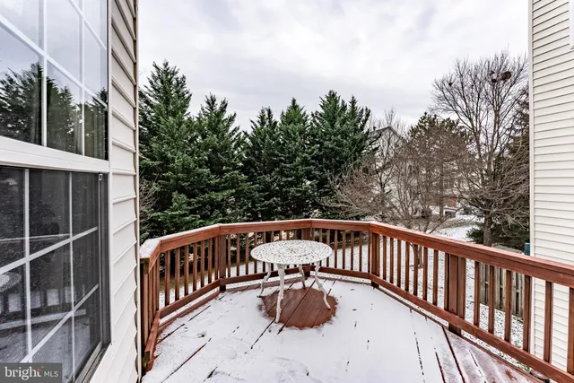 a view of a roof deck with couches and wooden fence