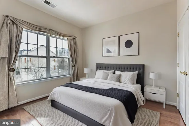 a bedroom with a bed and a large window