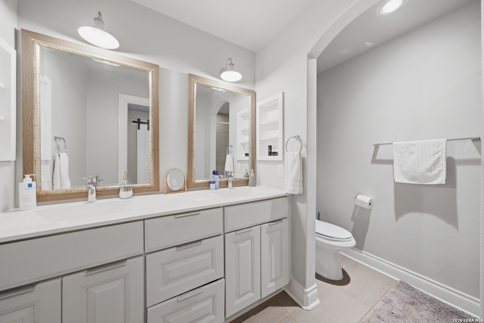 10042 Rafter S Trail Helotes, TX 78023 - Photo 40 of 69 a spacious bathroom with a double vanity sink a toilet and a mirror