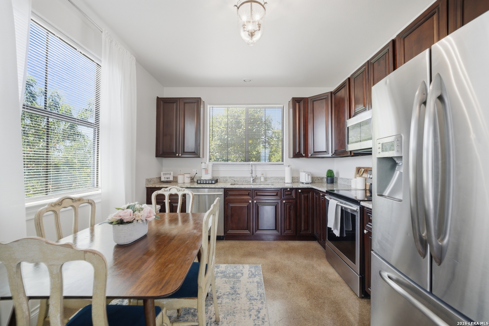 10042 Rafter S Trail Helotes, TX 78023 - Photo 61 of 69 a kitchen with stainless steel appliances granite countertop a refrigerator a stove a sink dishwasher a dining table and chairs with wooden floor